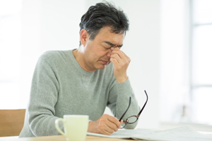 目をしかめる男性